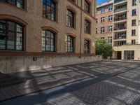 a brick courtyard has steps leading up to it, and a blue umbrella is on the ground