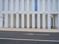 a white parking space next to a street with concrete columns at the corner of it