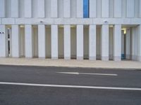 a white parking space next to a street with concrete columns at the corner of it