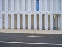 a white parking space next to a street with concrete columns at the corner of it