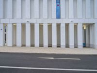 a white parking space next to a street with concrete columns at the corner of it