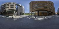 this is a 360 - sphere image of an outside building with a circular reflection of the building across the street