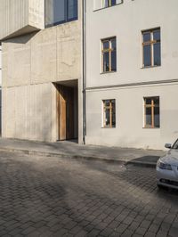 a person with a suitcase walking across an outside courtyard in front of a building,