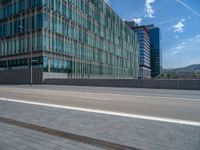 there is an empty street next to the building and parking area on the sidewalk where it seems