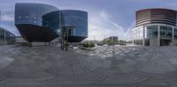 a fish eye lens is of some buildings and cars near a street light and street lamp