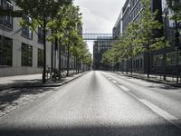 the empty empty street is seen with cars parked in the background, some buildings and bicycles are seen behind