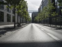 the empty empty street is seen with cars parked in the background, some buildings and bicycles are seen behind