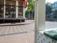 an open doorway shows a small sidewalk outside of a store with some shops in the window