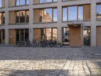 bicycles are parked in front of the outside buildings in an old town, where many brick houses are also occupied