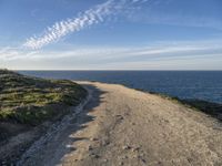 a scenic path with beach and sea on a clear day with the sky in the background