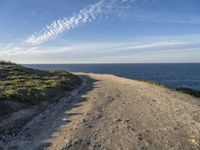 a scenic path with beach and sea on a clear day with the sky in the background