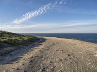 a scenic path with beach and sea on a clear day with the sky in the background