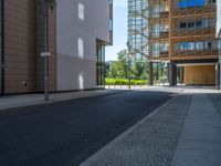 a road through which is a large modern building with an awning over it's entrance