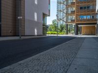 a road through which is a large modern building with an awning over it's entrance