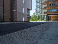 a road through which is a large modern building with an awning over it's entrance