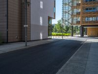 a road through which is a large modern building with an awning over it's entrance