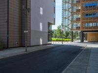 a road through which is a large modern building with an awning over it's entrance