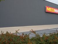 the entrance of an industrial warehouse building, with a sign above it that says mechania