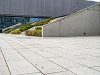 a view of steps from building to a staircase with shrubbery lining the walkway and bushes in front of it