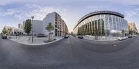 a fish eye view of cars passing under the streetlights in front of the building