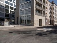 buildings and street signs are reflected in this photograph of a street lined with parked cars