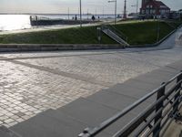 an empty walkway leads to a body of water and land near the waterfront in a city