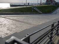 an empty walkway leads to a body of water and land near the waterfront in a city