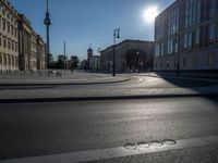 a street light next to an empty road in front of a building with a traffic light on top of it