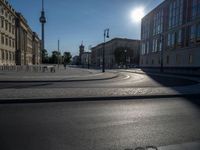 a street light next to an empty road in front of a building with a traffic light on top of it