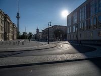 a street light next to an empty road in front of a building with a traffic light on top of it