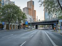 a city street that has a bridge over the road at sunset on a clear day