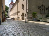 a brick street with two buildings and benches next to each other, and a sign that reads brunchner