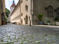 a brick street with two buildings and benches next to each other, and a sign that reads brunchner