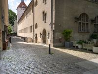 a brick street with two buildings and benches next to each other, and a sign that reads brunchner