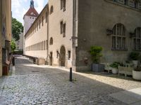 a brick street with two buildings and benches next to each other, and a sign that reads brunchner