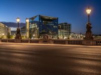 the city skyline is at night from the street level with traffic and pedestrians walking on it