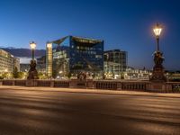 the city skyline is at night from the street level with traffic and pedestrians walking on it