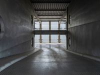 an empty walkway with a large open area behind it and a large door leading to the top