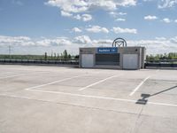 a parking lot with a building in the background and a lot for motorcycles to drive