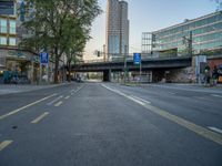 a city street that has a bridge over the road at sunset on a clear day