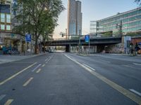 a city street that has a bridge over the road at sunset on a clear day