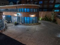 some dark blue windows in an industrial building with no one on the street to the right