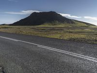 a person riding a bike down the road on a very sunny day in iceland, europe