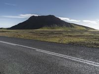 a person riding a bike down the road on a very sunny day in iceland, europe