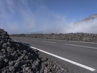 the road has been closed to traffic as it travels by itself in front of a very dry mountain