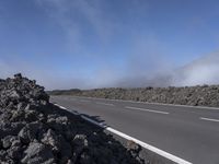 the road has been closed to traffic as it travels by itself in front of a very dry mountain