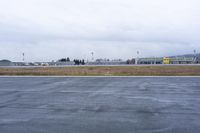 an industrial area with a parking lot and runway under construction and cloudy skies above it