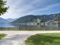 a scenic view of the mountains and a lake surrounded by trees with a fence in front