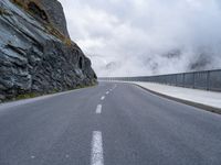 an asphalt road near some rocky and low mountains on a cloudy day to show the speed