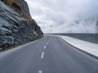 an asphalt road near some rocky and low mountains on a cloudy day to show the speed